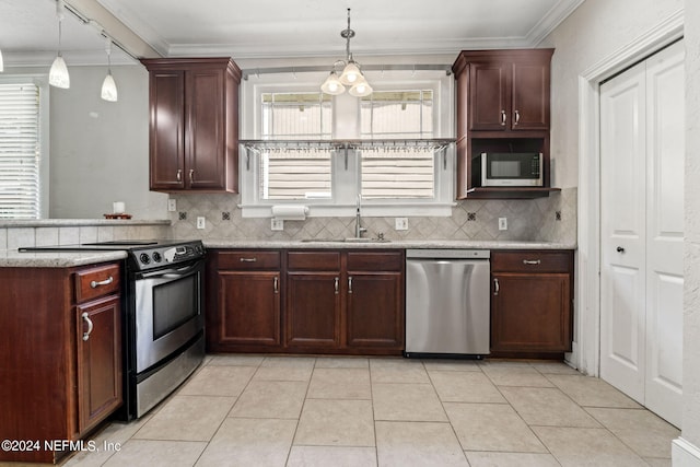 kitchen with crown molding, stainless steel appliances, a sink, and decorative backsplash