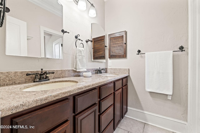 full bathroom with double vanity, ornamental molding, a sink, and tile patterned floors