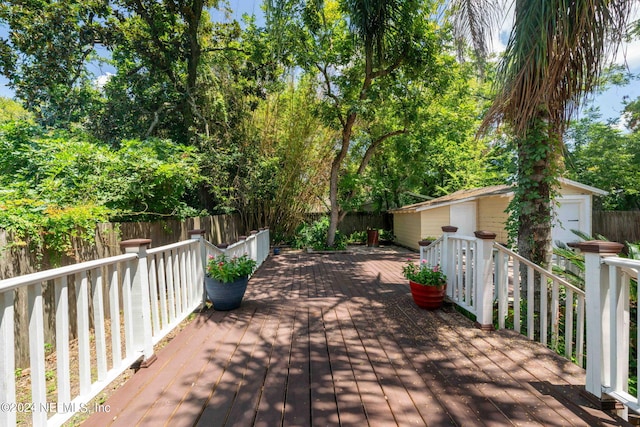 deck with a fenced backyard, a shed, and an outdoor structure