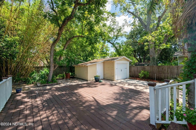 wooden terrace with an outbuilding, a fenced backyard, a detached garage, and a storage unit