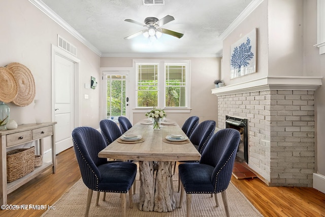 dining area with visible vents, ornamental molding, and wood finished floors