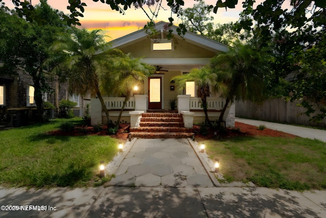 view of front of house featuring a porch, a front yard, and fence