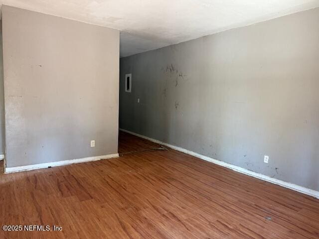 unfurnished room featuring wood finished floors and baseboards