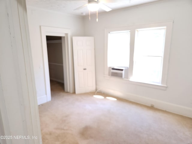 unfurnished room with carpet floors, cooling unit, a ceiling fan, and baseboards