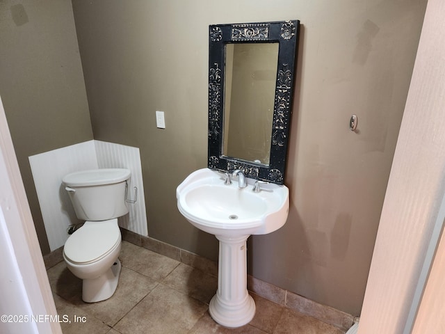 bathroom featuring baseboards, toilet, and tile patterned floors