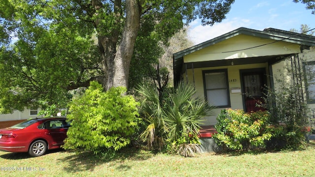 exterior space featuring covered porch and a front lawn