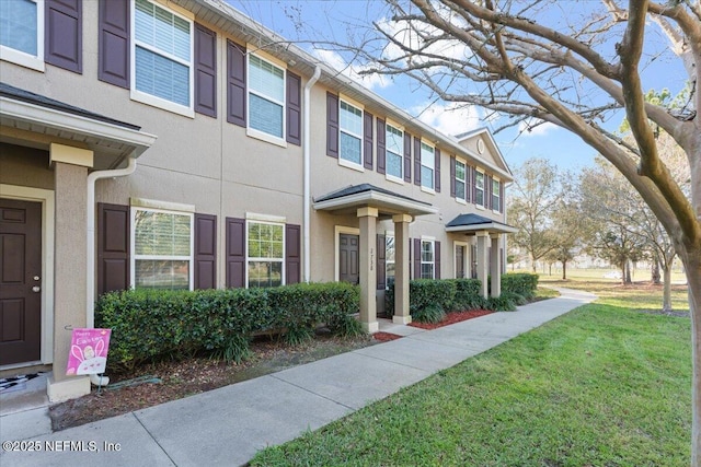 view of side of property featuring a lawn and stucco siding