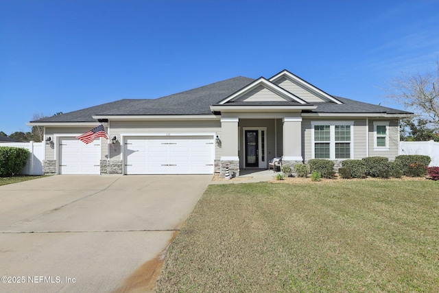 view of front facade with concrete driveway, an attached garage, a front yard, fence, and stone siding