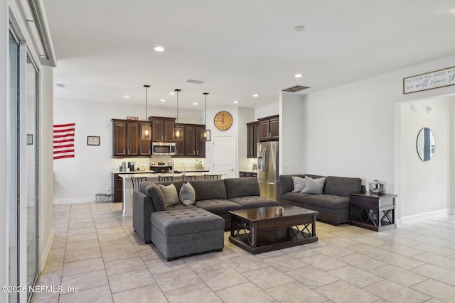 living area with baseboards, light tile patterned flooring, visible vents, and recessed lighting