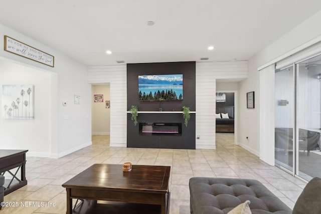 tiled living room with recessed lighting, baseboards, and a glass covered fireplace