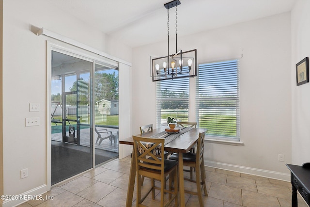 dining room with light tile patterned flooring, an inviting chandelier, and baseboards