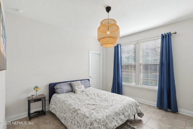 bedroom with light tile patterned flooring and baseboards