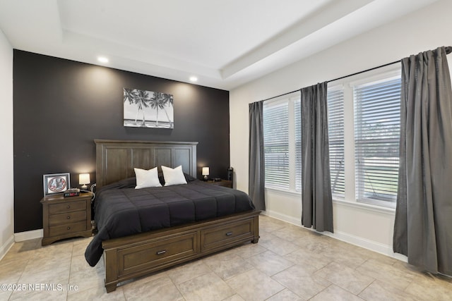 bedroom featuring a tray ceiling, light tile patterned floors, baseboards, and recessed lighting