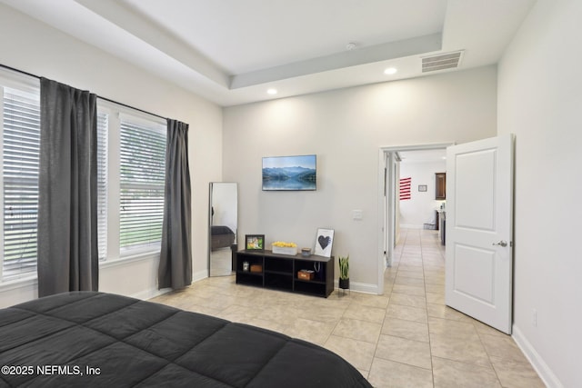 bedroom featuring a tray ceiling, light tile patterned floors, recessed lighting, visible vents, and baseboards