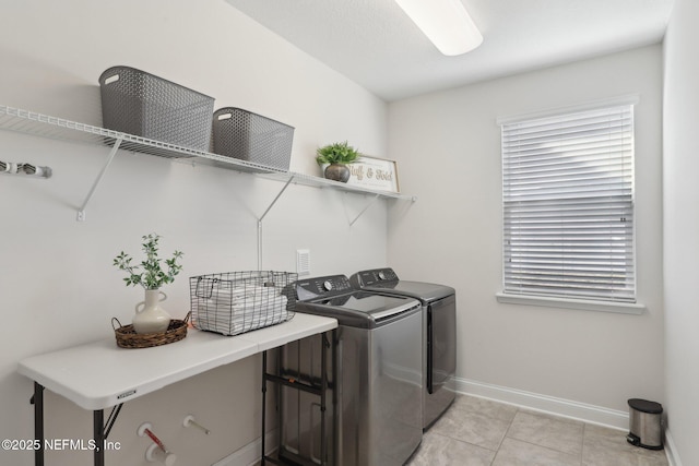 laundry room featuring laundry area, light tile patterned floors, baseboards, a healthy amount of sunlight, and separate washer and dryer