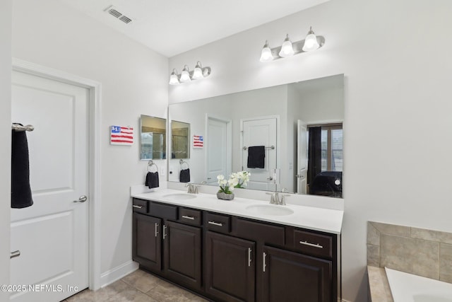 full bathroom with a bathtub, tile patterned floors, a sink, and double vanity