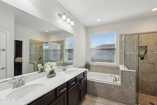 ensuite bathroom with a stall shower, double vanity, a sink, and a bath