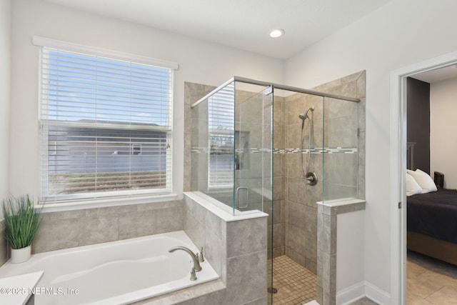 ensuite bathroom with tile patterned floors, connected bathroom, a bath, and a shower stall