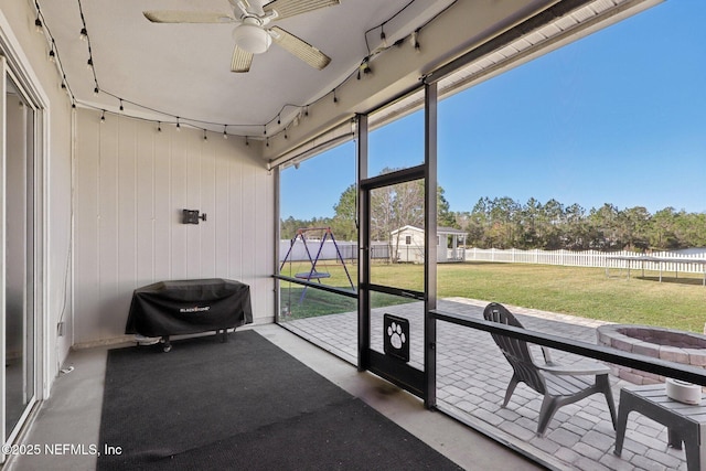 sunroom featuring a ceiling fan and track lighting