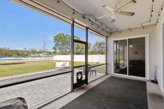 unfurnished sunroom featuring a ceiling fan