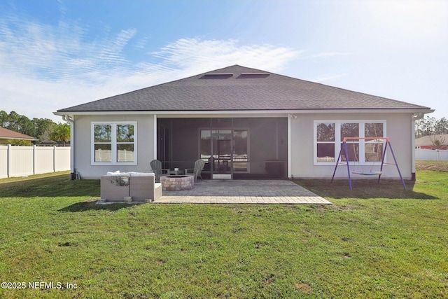 rear view of property featuring an outdoor fire pit, fence, roof with shingles, a lawn, and a patio area