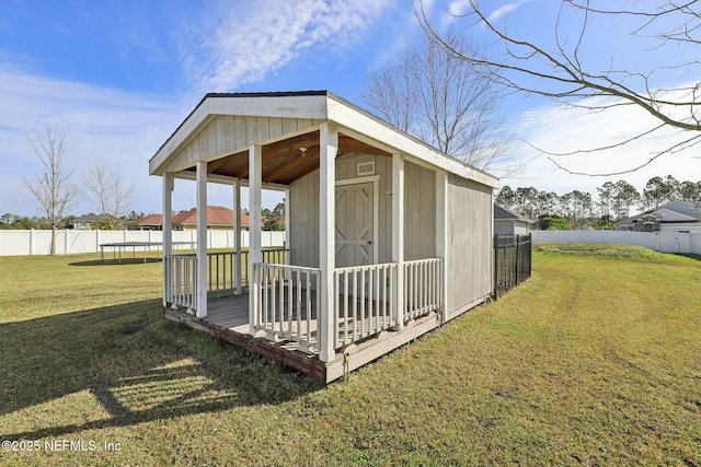 view of shed with a trampoline and a fenced backyard