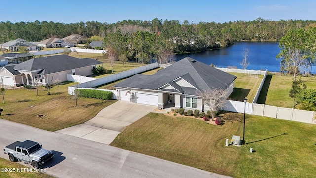 view of front of property featuring a garage, concrete driveway, a water view, fence, and a front lawn