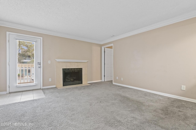 unfurnished living room featuring a textured ceiling, carpet flooring, baseboards, ornamental molding, and a tiled fireplace