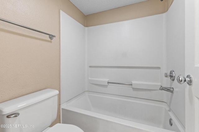 full bathroom featuring a textured ceiling, a textured wall, tub / shower combination, and toilet