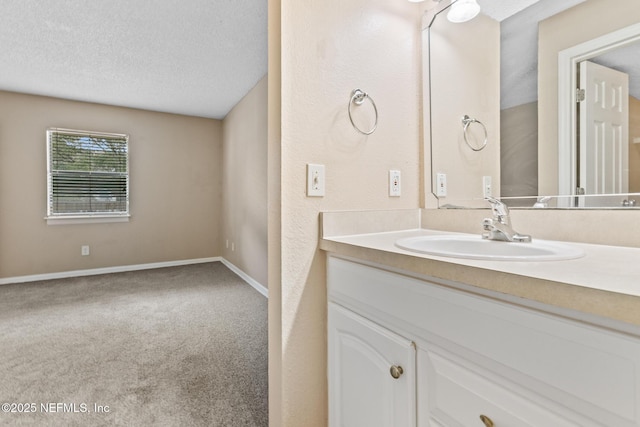 bathroom with baseboards, a textured ceiling, and vanity