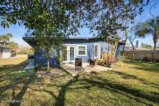 rear view of property featuring a yard, french doors, fence, and a patio