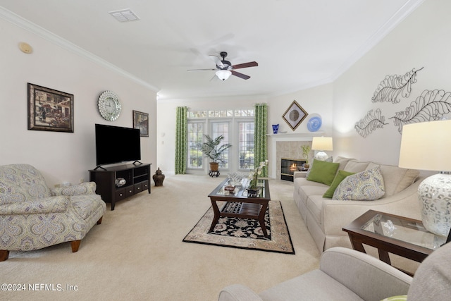 carpeted living area featuring a ceiling fan, visible vents, ornamental molding, and a tiled fireplace