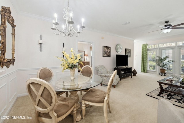 dining area featuring ornamental molding, a decorative wall, wainscoting, and light colored carpet