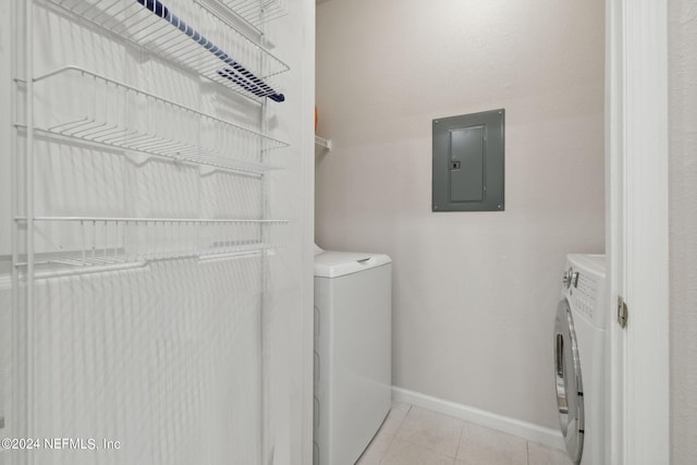 laundry area featuring washer and clothes dryer, light tile patterned floors, laundry area, electric panel, and baseboards