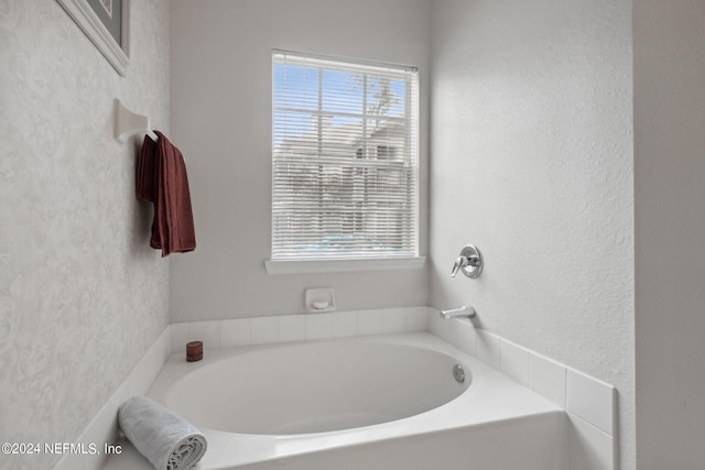 bathroom featuring a healthy amount of sunlight and a bath