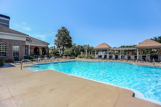 community pool featuring a gazebo, a patio area, and fence