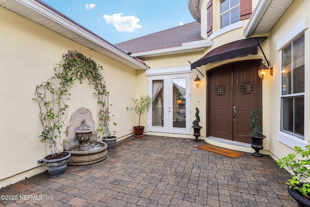 entrance to property with french doors and stucco siding