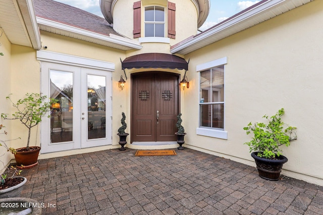 property entrance with french doors and stucco siding