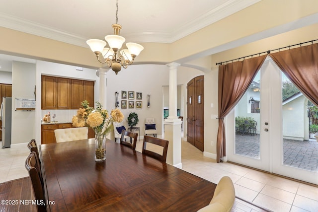 dining area featuring light tile patterned floors, ornamental molding, arched walkways, and decorative columns