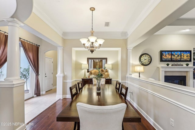 dining room featuring crown molding, decorative columns, and a chandelier