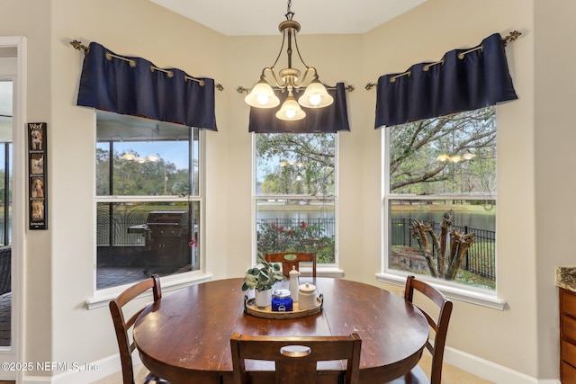 dining area with baseboards and a notable chandelier