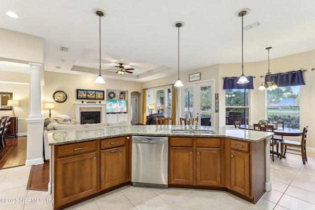 kitchen featuring a sink, stainless steel dishwasher, open floor plan, a raised ceiling, and ceiling fan