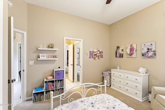 bedroom featuring a ceiling fan, ensuite bathroom, and light carpet