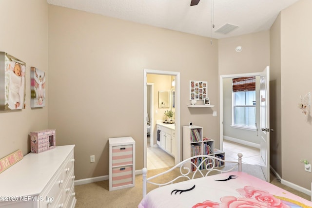 bedroom with ensuite bath, baseboards, visible vents, and light carpet