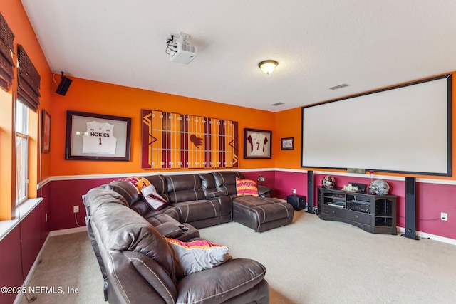 carpeted home theater featuring visible vents and baseboards