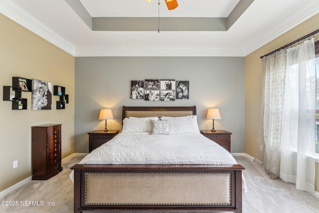 bedroom with a raised ceiling, light colored carpet, and baseboards