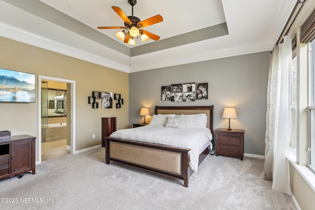 bedroom featuring baseboards, ceiling fan, light carpet, a raised ceiling, and connected bathroom