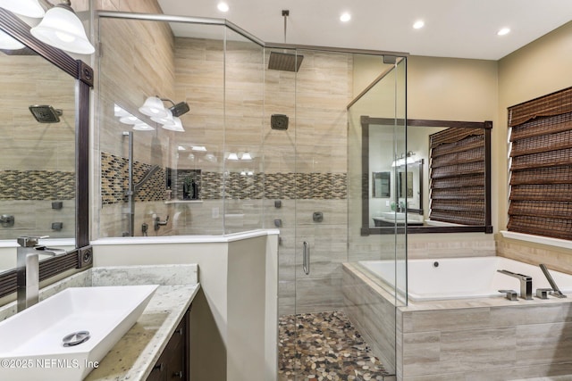 bathroom featuring a bath, recessed lighting, a shower stall, and vanity