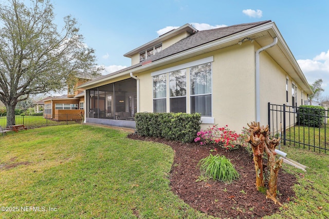 back of house with stucco siding, a lawn, fence, and a sunroom