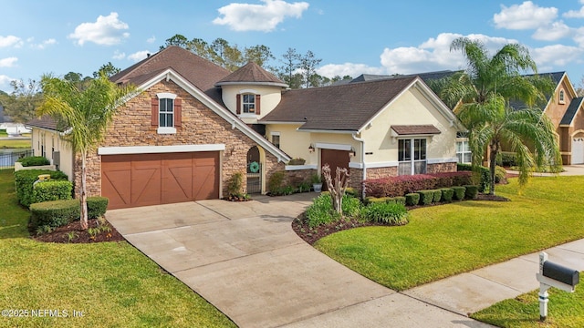 view of front of house with an attached garage, a front yard, stucco siding, stone siding, and driveway